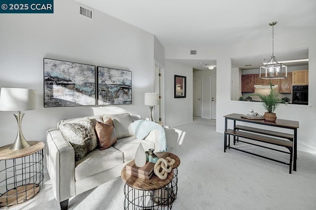 carpeted living room with a chandelier