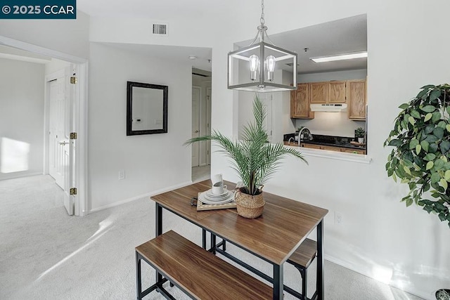 carpeted dining room with a chandelier and sink