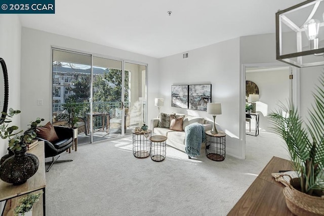 living room with light carpet and an inviting chandelier