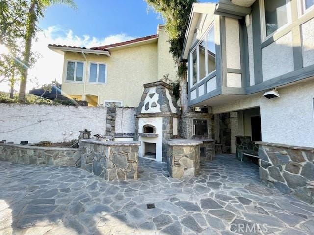 view of patio with exterior fireplace