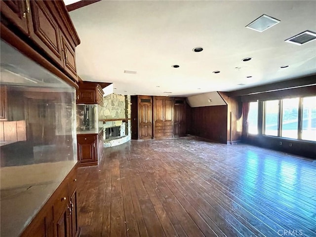 unfurnished living room featuring dark hardwood / wood-style flooring and wood walls