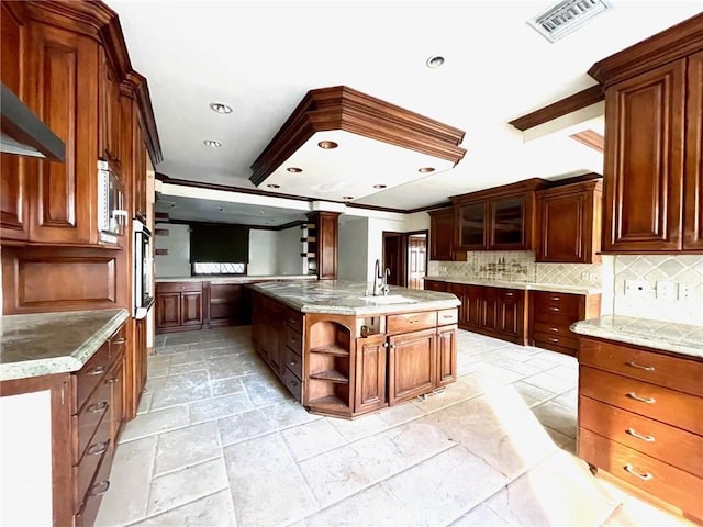 kitchen with backsplash, a center island, wall chimney range hood, ornamental molding, and sink