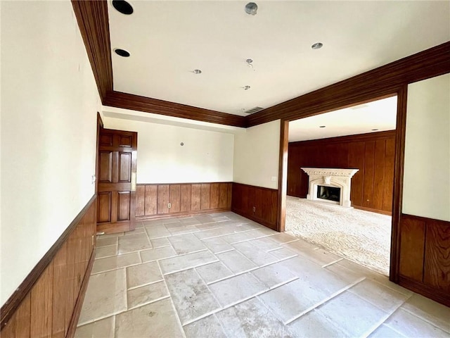 unfurnished living room with light colored carpet and crown molding