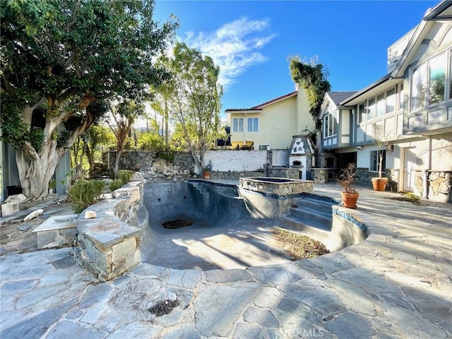 view of patio featuring an in ground hot tub