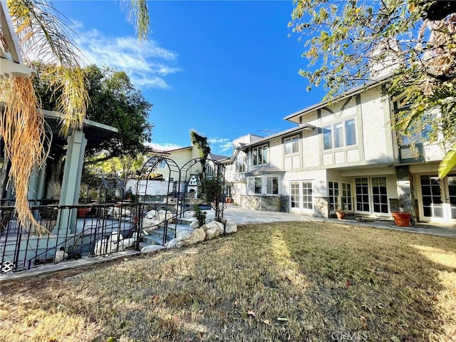 rear view of house with french doors and a yard