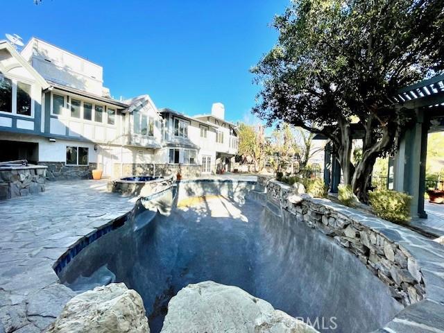 view of swimming pool featuring a patio and an in ground hot tub