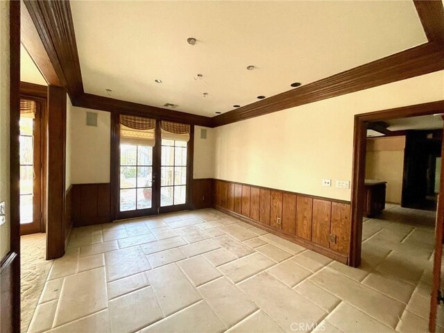 unfurnished room featuring ornamental molding and french doors