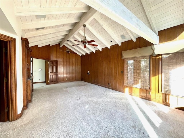 unfurnished living room with ceiling fan, light colored carpet, lofted ceiling with beams, and wooden walls