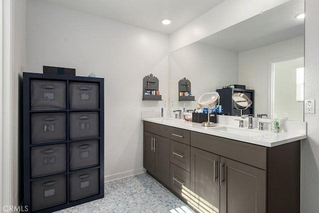 full bath with recessed lighting, a sink, baseboards, and double vanity