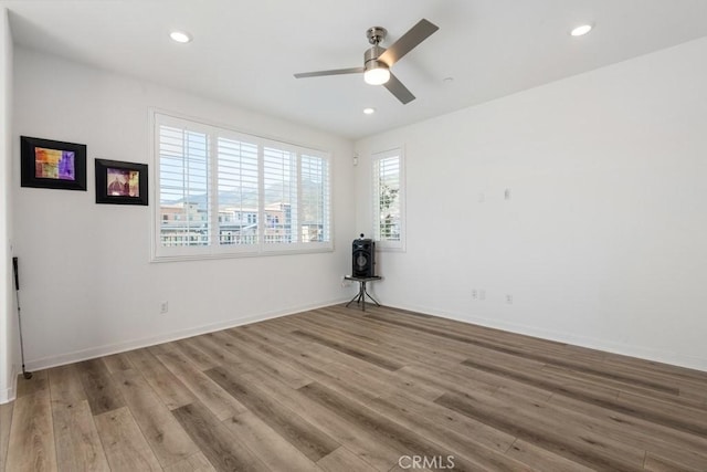 empty room featuring recessed lighting, baseboards, and wood finished floors