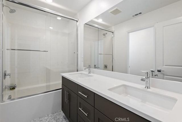 bathroom with enclosed tub / shower combo, visible vents, a sink, and double vanity