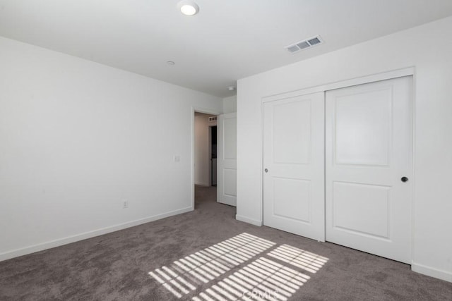 unfurnished bedroom featuring carpet floors, a closet, visible vents, and baseboards