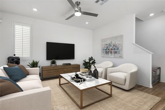 living room featuring light wood-style flooring, visible vents, ceiling fan, and recessed lighting