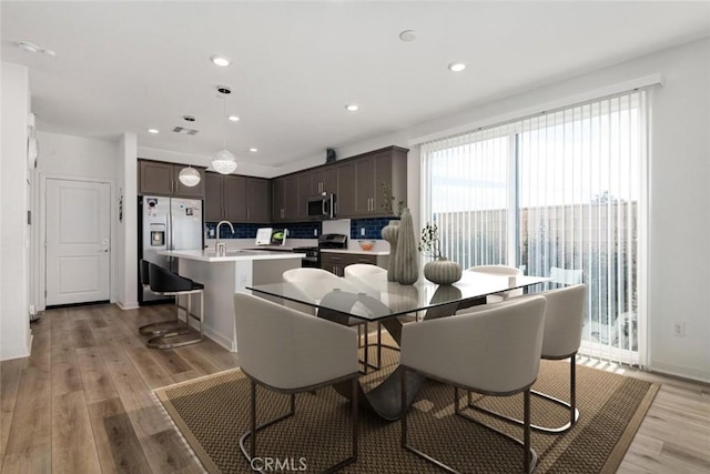 dining area featuring light wood-style floors, baseboards, and recessed lighting