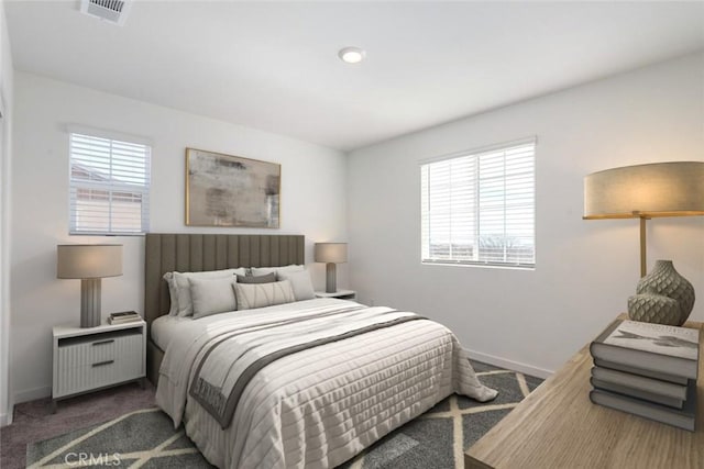 carpeted bedroom featuring baseboards, multiple windows, and visible vents