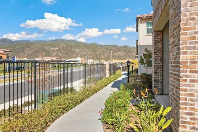 view of home's community with fence and a mountain view