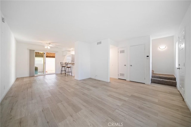 unfurnished living room with ceiling fan and light wood-type flooring