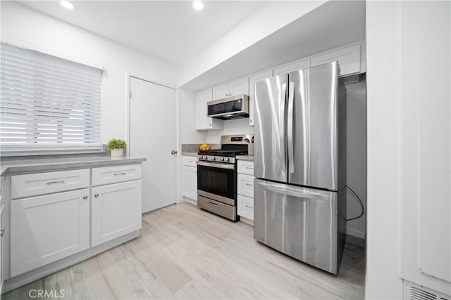 kitchen featuring appliances with stainless steel finishes, white cabinetry, and light hardwood / wood-style flooring