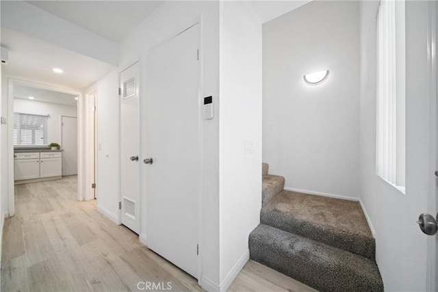 hallway with light hardwood / wood-style floors