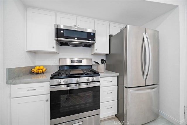 kitchen featuring stainless steel appliances and white cabinets