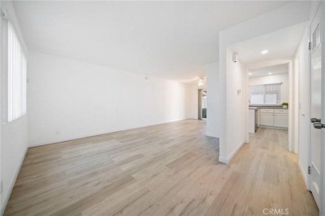 empty room featuring light wood-type flooring, ceiling fan, and a wealth of natural light