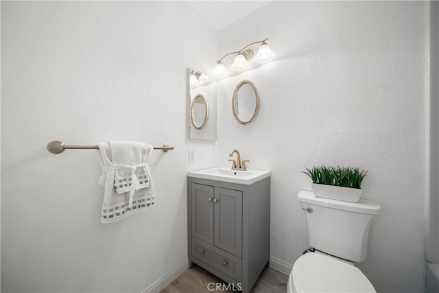 bathroom with hardwood / wood-style floors, toilet, and vanity