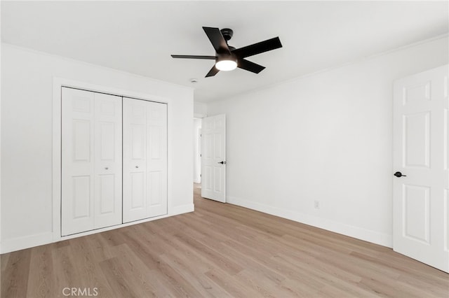 unfurnished bedroom featuring ceiling fan, a closet, and light wood-type flooring