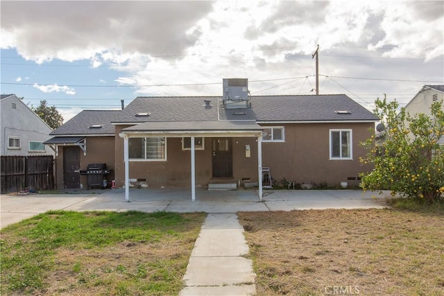 back of house with central AC unit and a yard