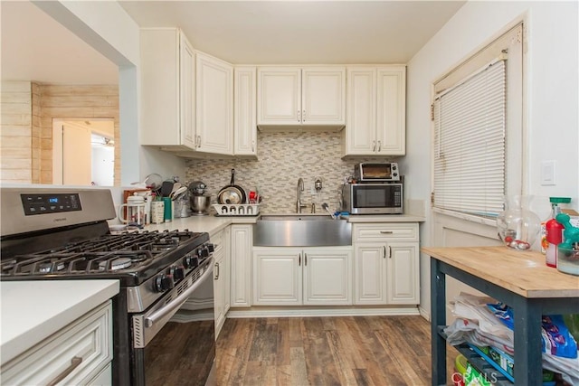 kitchen with sink, white cabinets, appliances with stainless steel finishes, and dark hardwood / wood-style flooring