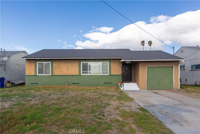 ranch-style home with a garage and a front lawn