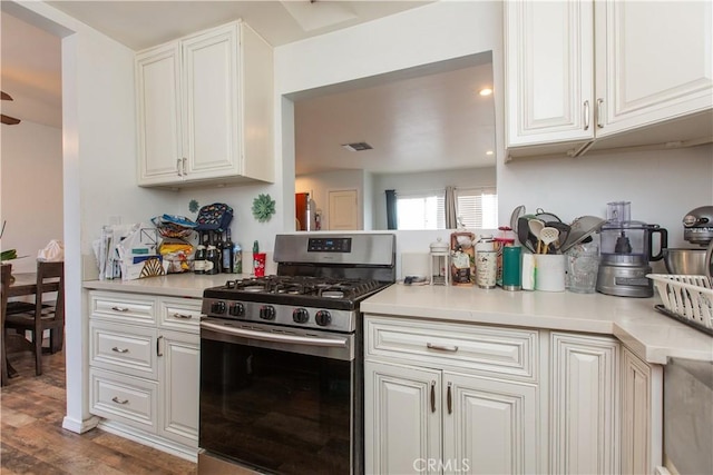 kitchen featuring dark wood-type flooring, white cabinets, and stainless steel gas range oven