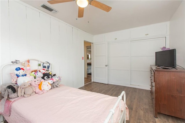 bedroom with ceiling fan, a closet, and dark wood-type flooring