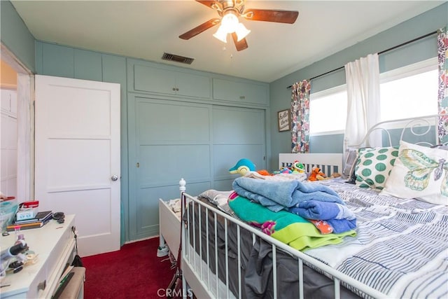 carpeted bedroom with ceiling fan and a closet