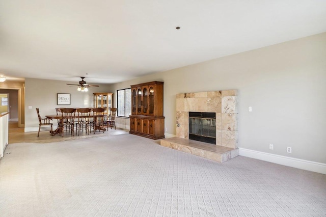 unfurnished living room with light colored carpet, a tile fireplace, and ceiling fan