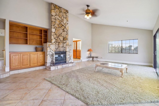 tiled living room featuring a stone fireplace, high vaulted ceiling, and ceiling fan