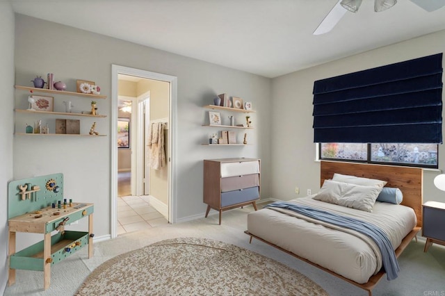 bedroom featuring ensuite bathroom, light carpet, and ceiling fan