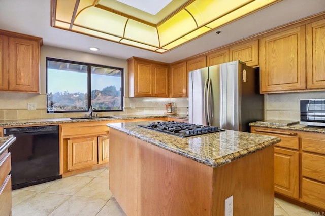 kitchen with sink, light stone counters, light tile patterned floors, a kitchen island, and stainless steel appliances