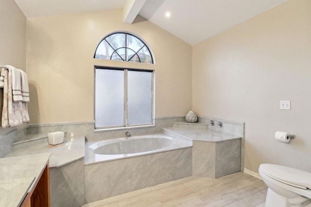 bathroom with hardwood / wood-style floors, vaulted ceiling with beams, tiled bath, vanity, and toilet