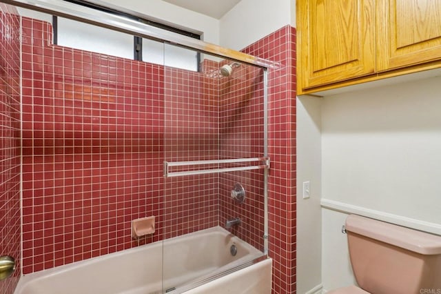 bathroom featuring tiled shower / bath and toilet