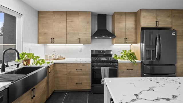 kitchen featuring refrigerator with ice dispenser, gas stove, dark tile patterned flooring, wall chimney range hood, and sink