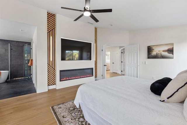 bedroom featuring ceiling fan, wood-type flooring, and ensuite bath