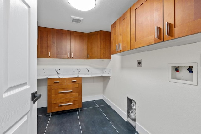 laundry room featuring washer hookup, cabinets, electric dryer hookup, and dark tile patterned floors