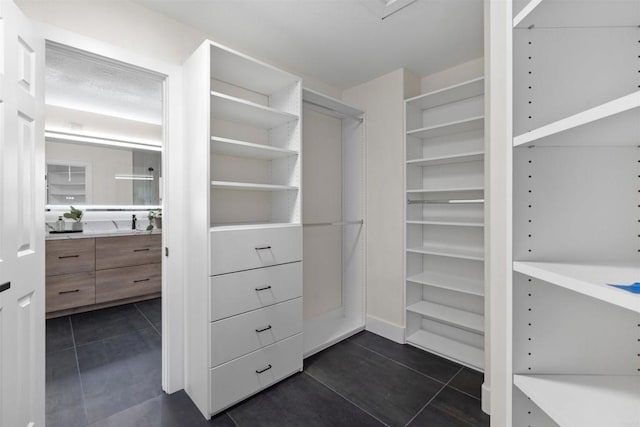 walk in closet with dark tile patterned floors