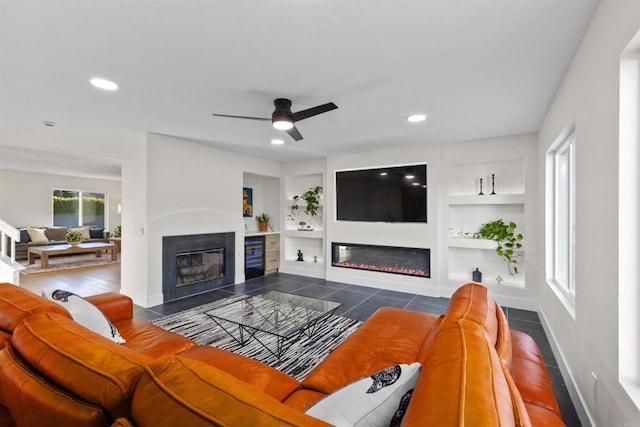 tiled living room featuring ceiling fan and built in shelves