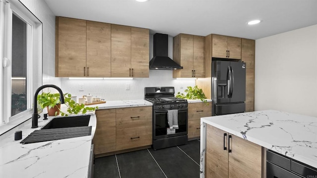 kitchen with dark tile patterned flooring, wall chimney exhaust hood, gas stove, sink, and black fridge with ice dispenser