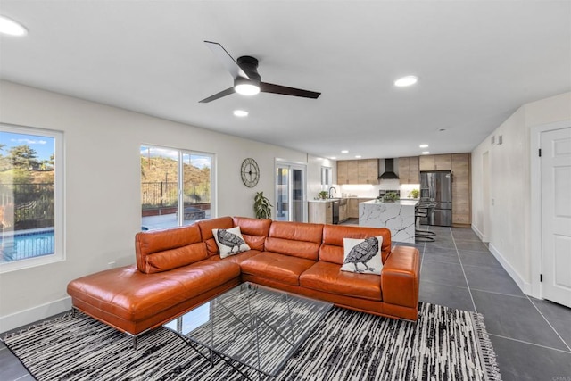 tiled living room with ceiling fan and a wealth of natural light