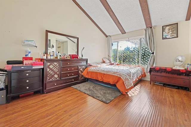 bedroom featuring beam ceiling, light hardwood / wood-style flooring, and high vaulted ceiling