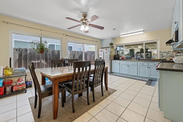 dining space with ceiling fan, sink, and light tile patterned floors