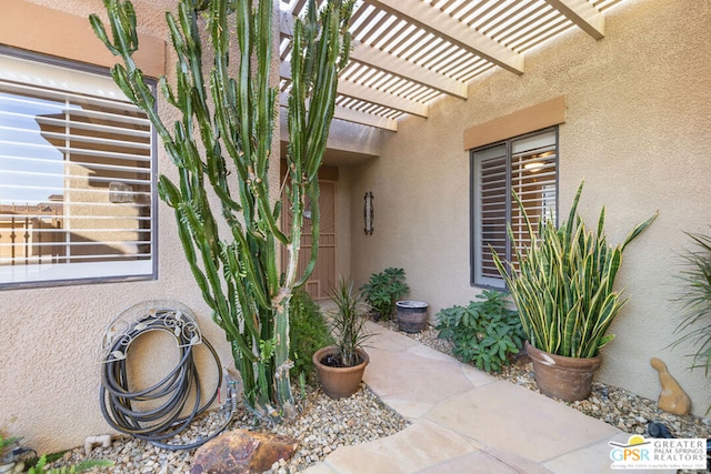 view of exterior entry featuring a pergola