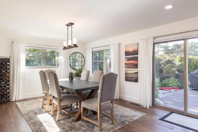 dining area featuring dark wood-type flooring and a chandelier